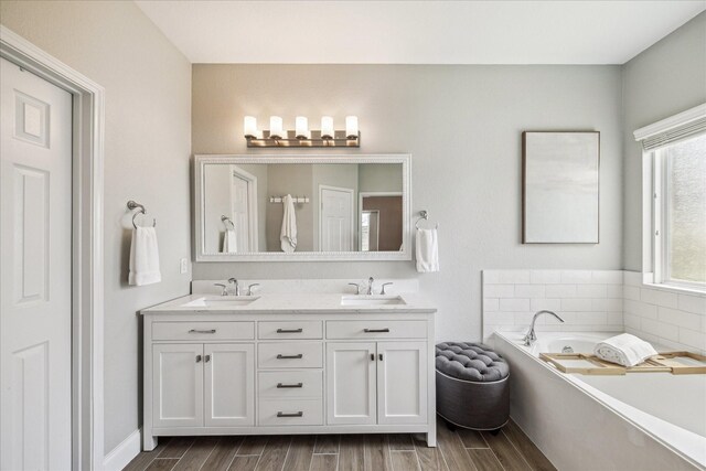 6903 Stevenson Dr, Missouri City, TX 77459 - full bathroom featuring double vanity, a bath, and wood tiled floors