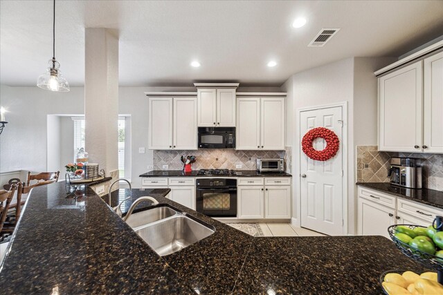 6903 Stevenson Dr, Missouri City, TX 77459 - kitchen with black appliances, dark stone counters, backsplash, pendant lighting, and recessed lighting