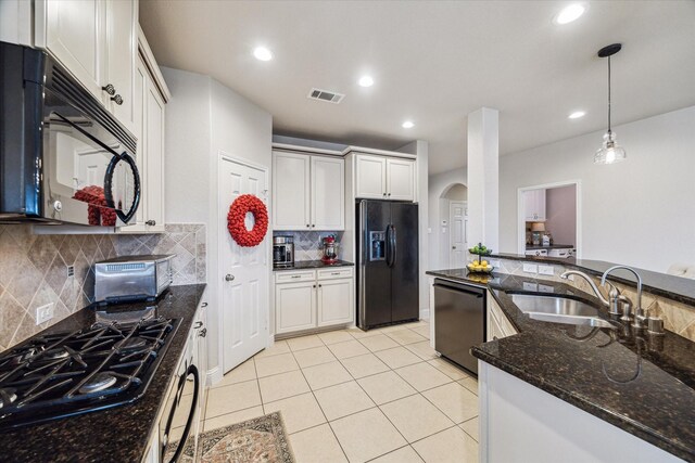 6903 Stevenson Dr, Missouri City, TX 77459 - kitchen with black appliances, arched walkways, decorative light fixtures, light tile patterned floors, and dark stone countertops