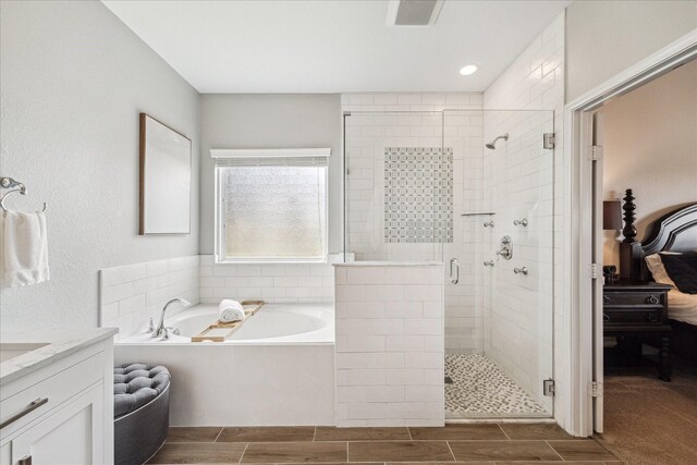 6903 Stevenson Dr, Missouri City, TX 77459 - ensuite bathroom featuring a bath, a stall shower, wood finish floors, and vanity