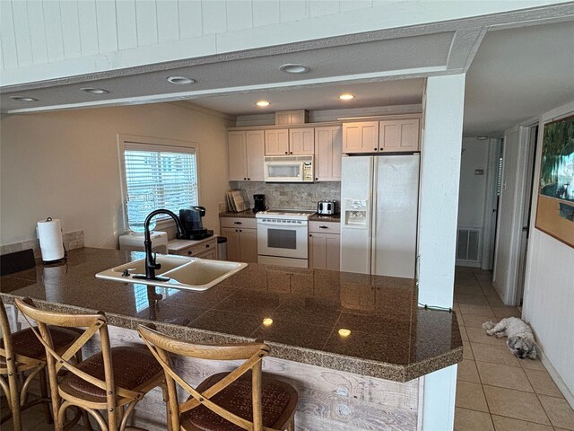 3514 Jolly Roger Cir, Galveston, TX 77554 - kitchen with white appliances, a kitchen breakfast bar, light tile patterned flooring, tile countertops, and a peninsula