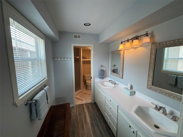 3514 Jolly Roger Cir, Galveston, TX 77554 - bathroom with double vanity, plenty of natural light, and wood finished floors