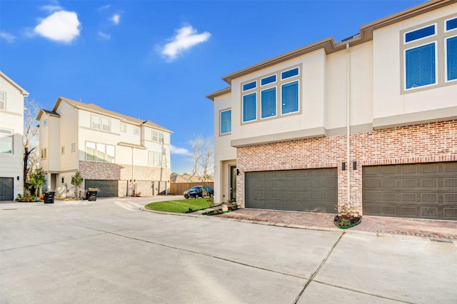 152 Knightsbridge Park Ln, Houston, TX 77018 - view of side of property featuring stucco siding, brick siding, driveway, and an attached garage