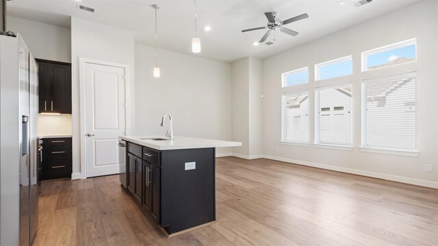 152 Knightsbridge Park Ln, Houston, TX 77018 - kitchen with appliances with stainless steel finishes, light wood-style floors, light countertops, an island with sink, and decorative light fixtures