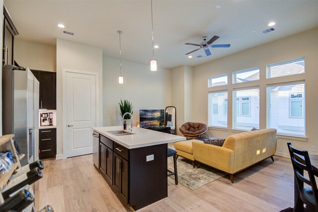 152 Knightsbridge Park Ln, Houston, TX 77018 - kitchen with a kitchen bar, light countertops, light wood-type flooring, open floor plan, and stainless steel appliances