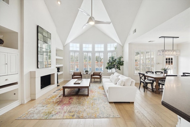 6403 Hidden Crest Way, Sugar Land, TX 77479 - living area featuring a fireplace, light wood-style flooring, built in shelves, and high vaulted ceiling