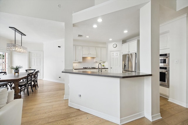 6403 Hidden Crest Way, Sugar Land, TX 77479 - kitchen with stainless steel appliances, dark countertops, light wood finished floors, backsplash, and recessed lighting