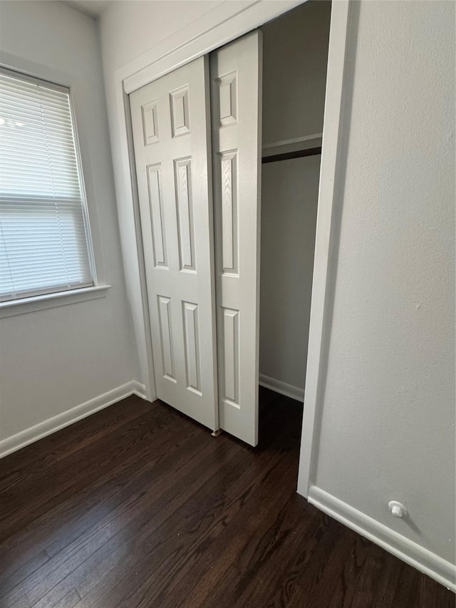 209 W 8th St, Deer Park, TX 77536 - unfurnished bedroom with dark wood-style flooring and a closet