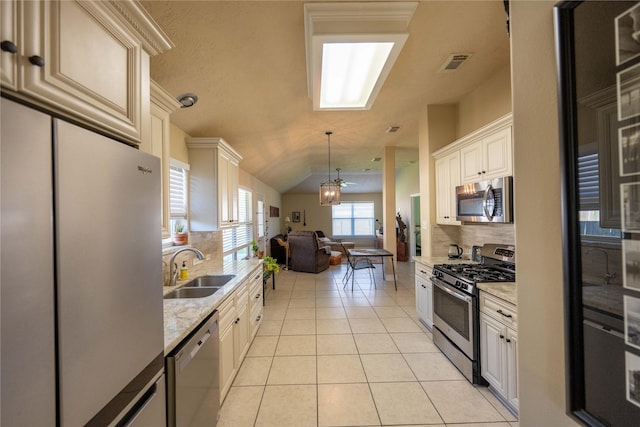 1409 Barras St, Alvin, TX 77511 - kitchen with appliances with stainless steel finishes, open floor plan, tasteful backsplash, light tile patterned floors, and light stone counters