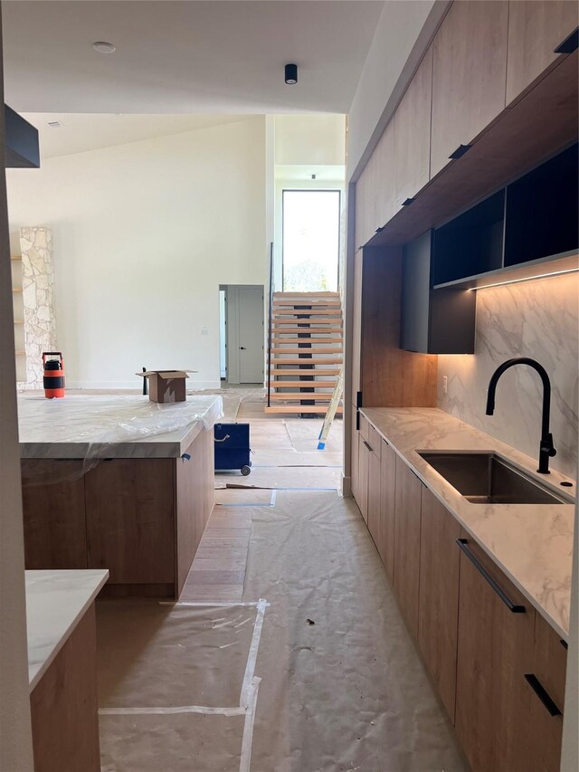 20410 Tealpointe Ridge Ln, Tomball, TX 77377 - kitchen with modern cabinets, light stone countertops, open floor plan, and tasteful backsplash