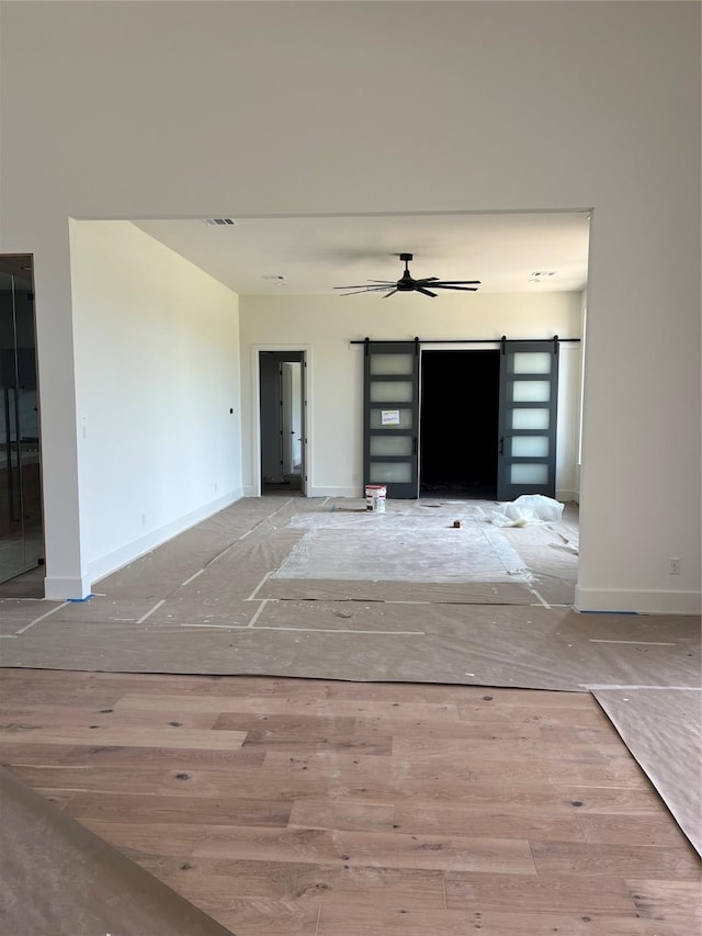 20410 Tealpointe Ridge Ln, Tomball, TX 77377 - unfurnished living room with a barn door and ceiling fan