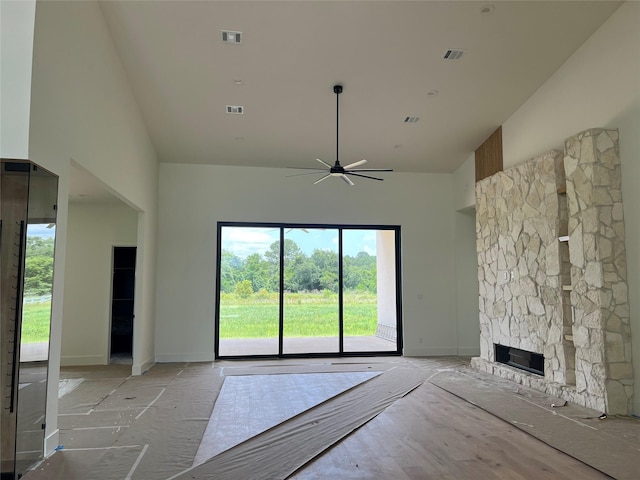 20410 Tealpointe Ridge Ln, Tomball, TX 77377 - unfurnished living room with high vaulted ceiling, healthy amount of natural light, a ceiling fan, and a stone fireplace