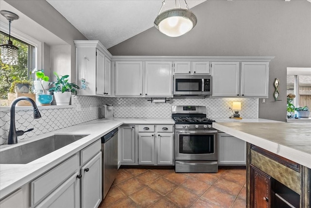 2004 Tuscarora Ct, League City, TX 77573 - kitchen featuring stainless steel appliances, vaulted ceiling, decorative backsplash, decorative light fixtures, and dark tile patterned floors