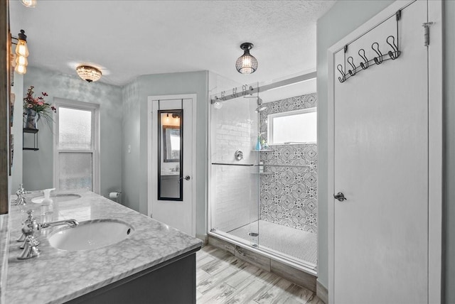 2004 Tuscarora Ct, League City, TX 77573 - full bath featuring a stall shower, healthy amount of natural light, wood finished floors, double vanity, and a textured ceiling
