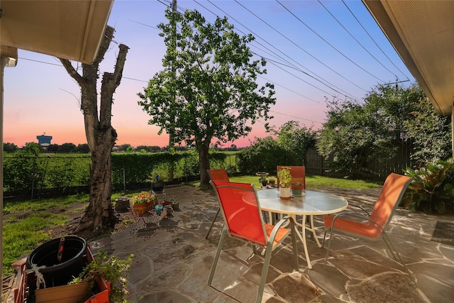 2004 Tuscarora Ct, League City, TX 77573 - patio terrace at dusk featuring outdoor dining area, a patio area, and a fenced backyard