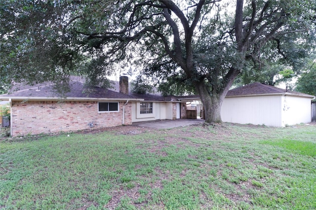 8302 Burning Hills Dr, Houston, TX 77071 - back of property featuring a chimney, a patio, a lawn, and brick siding