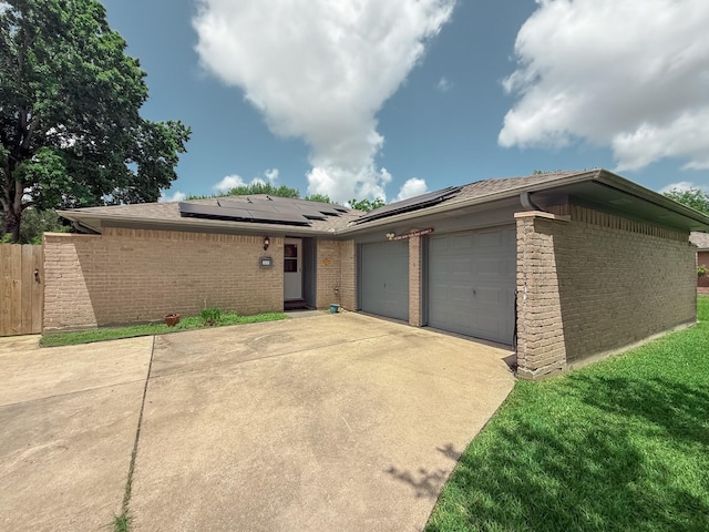 309 Baycrest Dr, League City, TX 77573 - view of front facade featuring brick siding, a garage, concrete driveway, and roof mounted solar panels