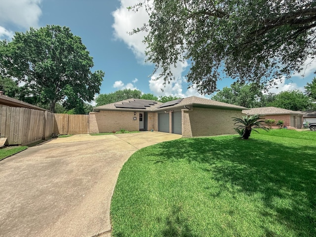 309 Baycrest Dr, League City, TX 77573 - rear view of property with roof mounted solar panels, a garage, brick siding, and concrete driveway