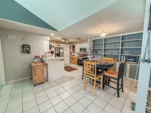 309 Baycrest Dr, League City, TX 77573 - dining area featuring a textured ceiling, light tile patterned flooring, and lofted ceiling