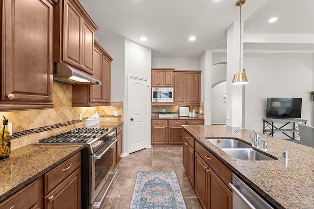 14 Painted Post Pl, The Woodlands, TX 77389 - kitchen with stainless steel appliances, under cabinet range hood, dark stone counters, backsplash, and recessed lighting