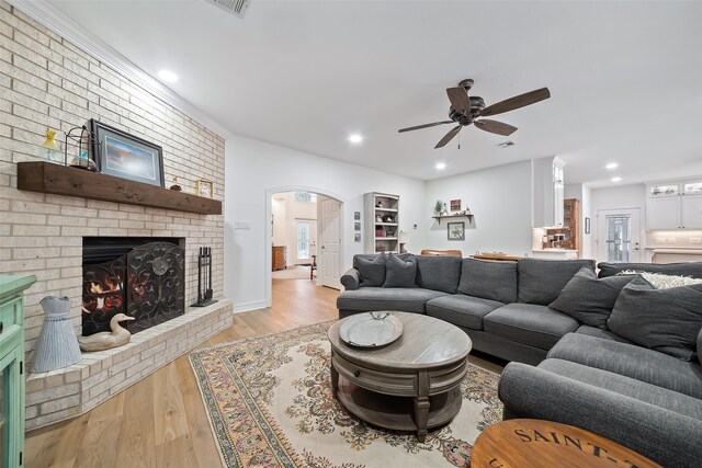6602 Ranch Park Dr, Magnolia, TX 77354 - living area featuring a brick fireplace, wood finished floors, ceiling fan, arched walkways, and recessed lighting