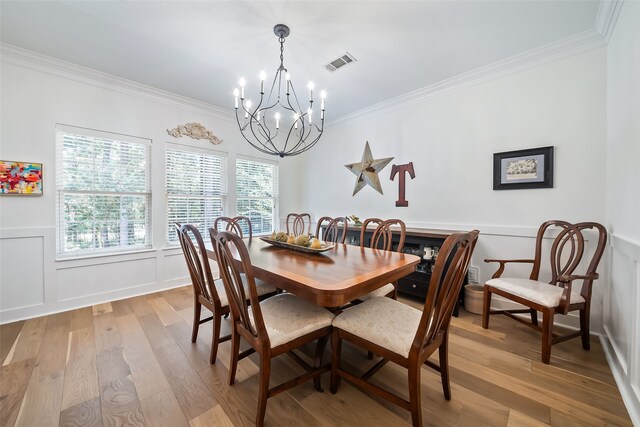 6602 Ranch Park Dr, Magnolia, TX 77354 - dining space featuring a chandelier, crown molding, light wood finished floors, a decorative wall, and wainscoting
