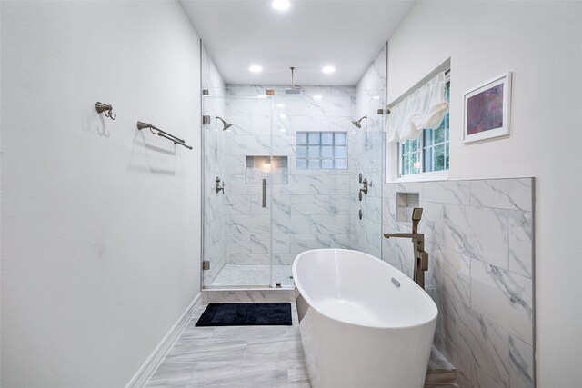 6602 Ranch Park Dr, Magnolia, TX 77354 - bathroom featuring a freestanding bath, a marble finish shower, recessed lighting, and marble look tiles
