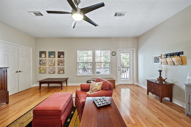 6602 Ranch Park Dr, Magnolia, TX 77354 - living room with light wood-style floors, a ceiling fan, and a textured ceiling