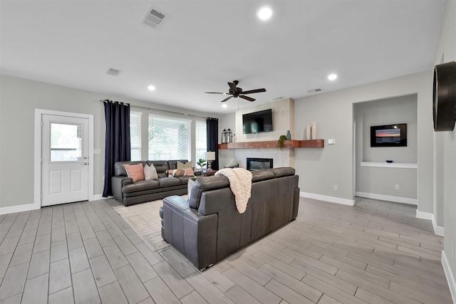 2411 Sunset Mist Ln, Conroe, TX 77304 - living area featuring a ceiling fan, light wood finished floors, a fireplace, and recessed lighting