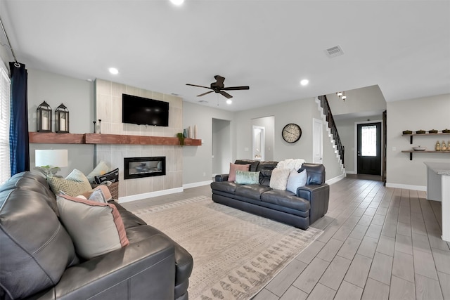 2411 Sunset Mist Ln, Conroe, TX 77304 - living area featuring a tile fireplace, recessed lighting, stairs, wood finished floors, and ceiling fan