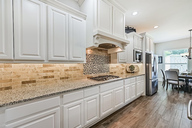 2424 Prairie Mist Ln, Friendswood, TX 77546 - kitchen featuring appliances with stainless steel finishes, white cabinetry, a chandelier, recessed lighting, and light stone counters