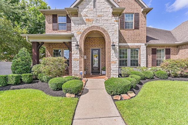2424 Prairie Mist Ln, Friendswood, TX 77546 - view of front of house featuring stone siding, a front lawn, brick siding, and roof with shingles