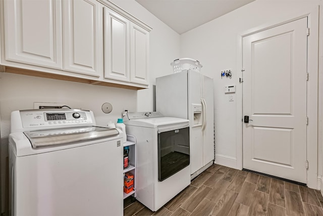 2424 Prairie Mist Ln, Friendswood, TX 77546 - laundry area featuring cabinet space, washing machine and clothes dryer, and wood finished floors