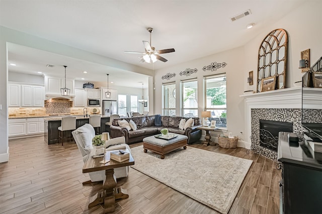 2424 Prairie Mist Ln, Friendswood, TX 77546 - living room with a ceiling fan, light wood finished floors, a fireplace, and recessed lighting