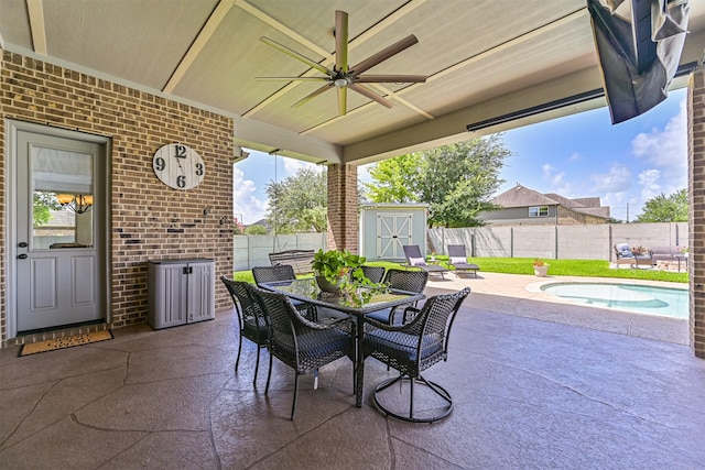 2424 Prairie Mist Ln, Friendswood, TX 77546 - fenced backyard with a patio, a storage unit, outdoor dining area, a ceiling fan, and a pool