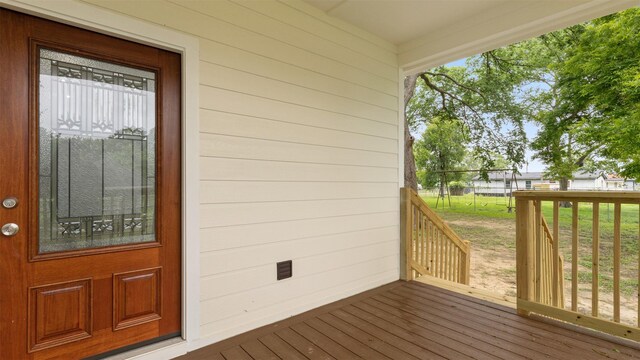 10002 Wilma Ln, Beach City, TX 77523 - doorway to property featuring a wooden deck and a lawn