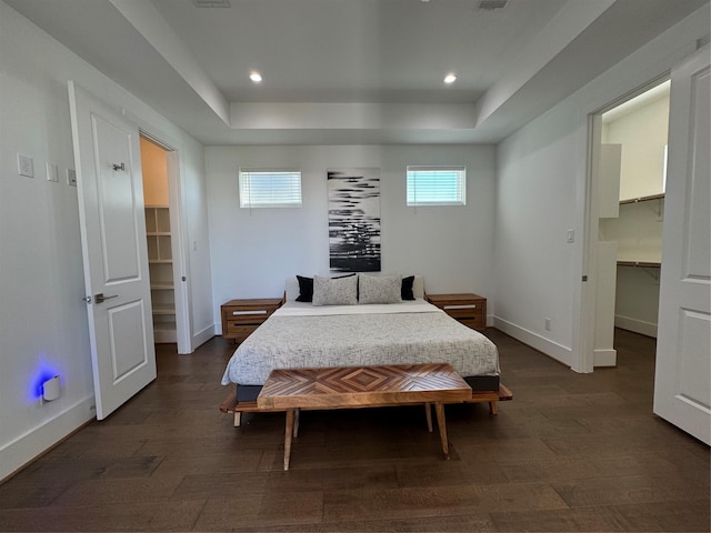 418 Bayou St, Houston, TX 77020 - bedroom featuring a walk in closet, a closet, a raised ceiling, dark wood-style flooring, and recessed lighting