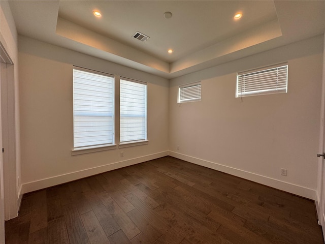 418 Bayou St, Houston, TX 77020 - empty room featuring a raised ceiling, dark wood-type flooring, and recessed lighting