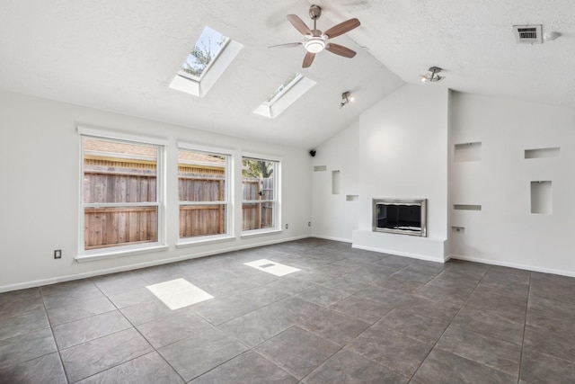 11406 Meadow Lake Dr, Houston, TX 77077 - unfurnished living room featuring ceiling fan, a skylight, a glass covered fireplace, a textured ceiling, and high vaulted ceiling