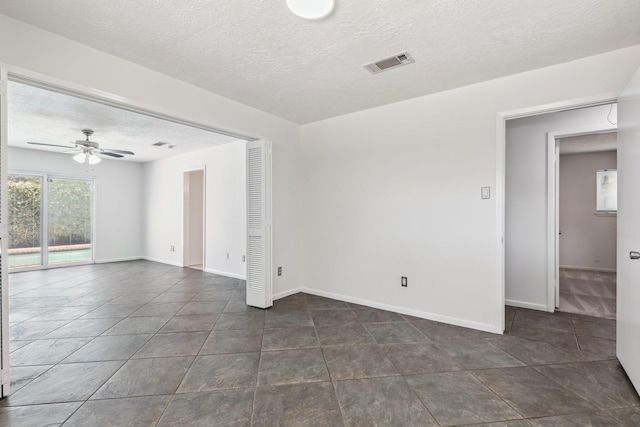 11406 Meadow Lake Dr, Houston, TX 77077 - empty room featuring a textured ceiling, ceiling fan, and dark tile patterned floors