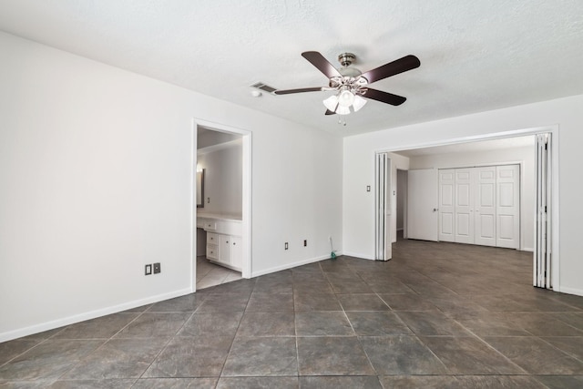 11406 Meadow Lake Dr, Houston, TX 77077 - unfurnished bedroom with ensuite bath, a ceiling fan, and dark tile patterned flooring