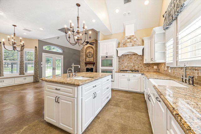 2215 Timbershade Ct, Magnolia, TX 77355 - kitchen with a chandelier, white double oven, lofted ceiling, french doors, and tasteful backsplash