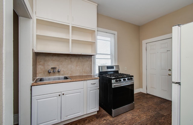 3412 Avenue S, Galveston, TX 77550 - kitchen featuring stainless steel gas range, freestanding refrigerator, open shelves, dark wood finished floors, and tasteful backsplash