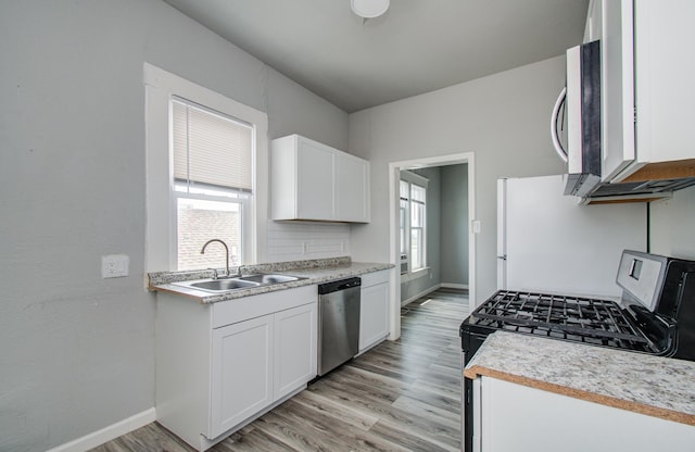 3412 Avenue S, Galveston, TX 77550 - kitchen featuring stainless steel appliances, healthy amount of natural light, light wood-style flooring, and light countertops