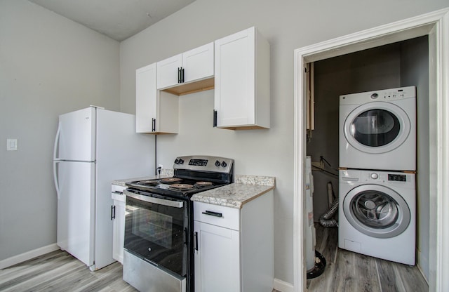3412 Avenue S, Galveston, TX 77550 - kitchen with electric stove, stacked washer / drying machine, light wood finished floors, and white cabinets