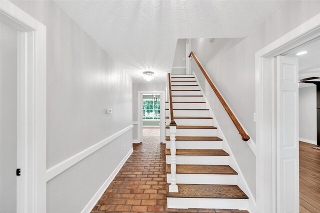738 Stone Mountain Dr, Conroe, TX 77302 - stairway featuring brick floors and baseboards