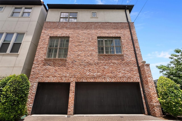 1156 Mosaico Ln, Houston, TX 77055 - view of front of house with decorative driveway, stucco siding, an attached garage, and brick siding