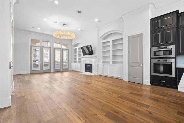 1156 Mosaico Ln, Houston, TX 77055 - unfurnished living room with crown molding, built in shelves, recessed lighting, light wood-style floors, and a fireplace