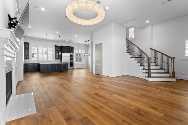 1156 Mosaico Ln, Houston, TX 77055 - unfurnished living room with stairs, light wood finished floors, a high end fireplace, ornamental molding, and recessed lighting