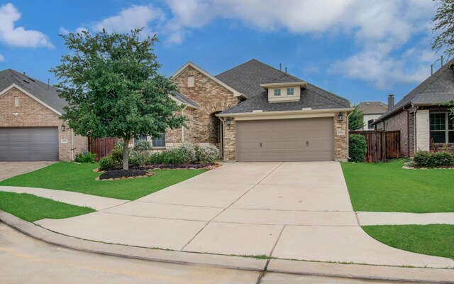6914 N Elmwood Trl, Katy, TX 77493 - view of front of house with brick siding, a garage, driveway, and roof with shingles